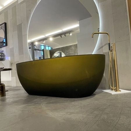 Vola Armatur in PVD Oberfläche mit Antonio Lupi Badewanne aus Cristalmood. Natursteinwand von Petra Antiqua